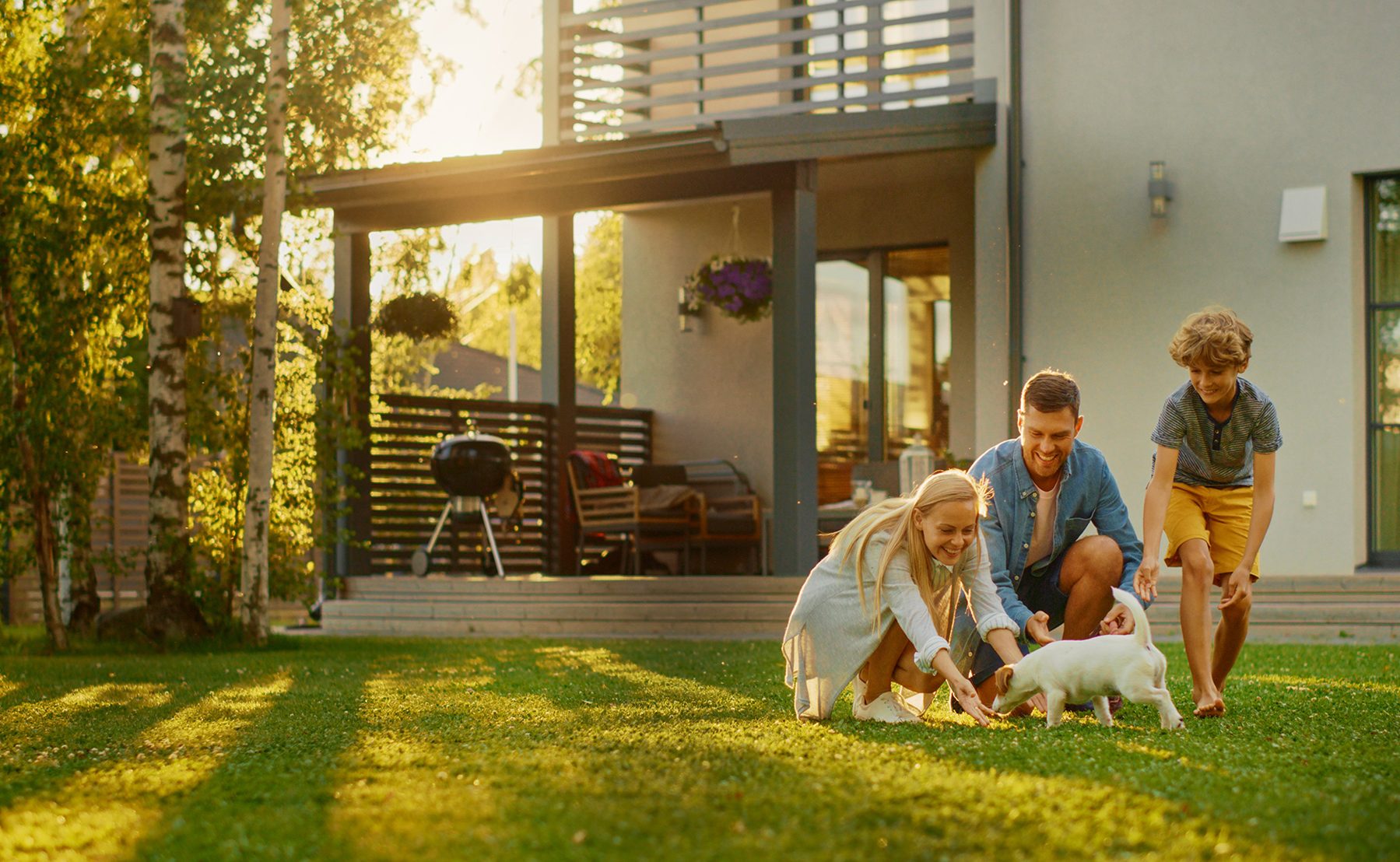 Family relaxing on the lawn outside their home at dusk